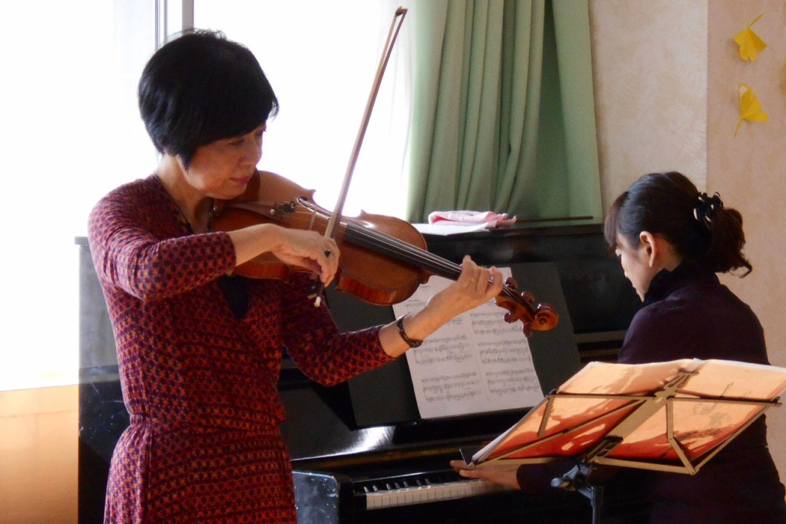 バイオリンレッスンの様子。入居者が講師から指導を受けている音楽活動。